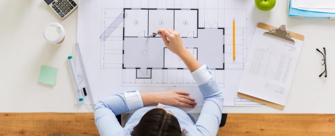 architect with compass measuring blueprint